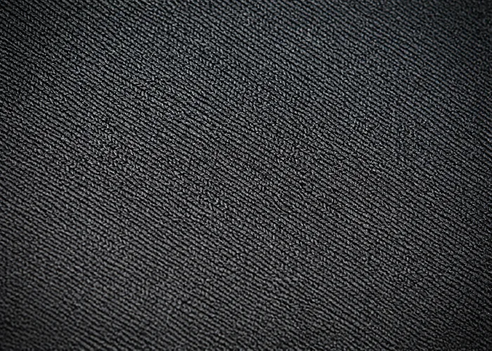 Close macro shot of double-knit polyester fabric, tighter and denser weave than the air knit base.