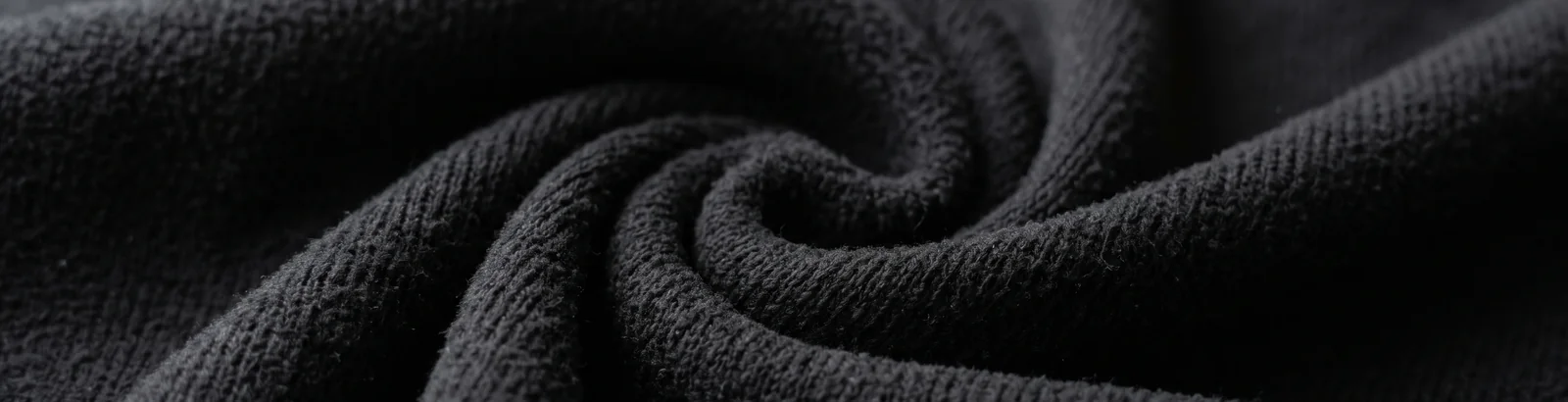 Close macro shot of undecorated fleece fabric in the Black colorway used for blank practice jerseys.