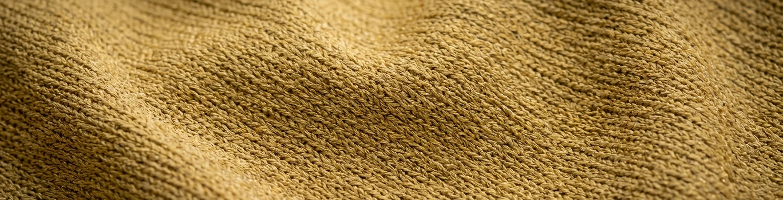 Close macro shot of undecorated knit fabric in the Vegas Gold colorway used for blank hockey socks.