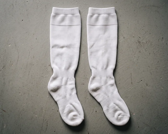 Blank white hockey socks laid flat, no crest, numbers, or wordmark.